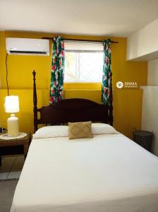 Un dormitorio con una gran cama blanca con ventana. en Zinnia Apartments Antigua, en Potters Village 27 fotos más