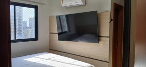 una camera da letto con una grande TV a schermo piatto a parete di Apartamento 2 quartos COP 30 a Belém