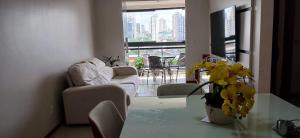 un soggiorno con un divano e un tavolo di vetro di Apartamento 2 quartos COP 30 a Belém