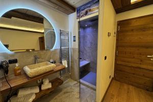 a bathroom with a shower with a sink and a mirror at La Locanda in Livigno +66 photos