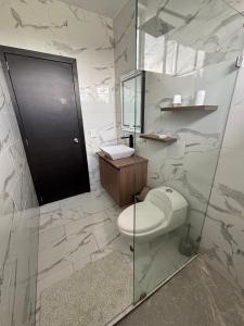 a bathroom with a toilet and a glass shower at Casa en Puyo Amazonía "Villa Coral" in Puyo +25 photos