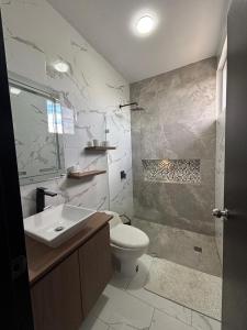 a bathroom with a toilet and a sink and a shower at Casa en Puyo Amazonía in Puyo