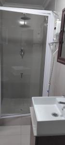 a bathroom with a glass shower and a sink at Solomon's Nest in Glencairn