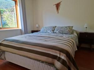 a bed in a bedroom with a window at Linda Casa Granizo, Olmue in El Cerrillo