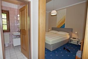 Un dormitorio con una cama y un baño con lavabo. en Hotel Kärntnerhof Velden, en Velden am Wörthersee