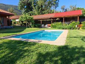 a swimming pool in a yard next to a house at Linda Casa Granizo, Olmue in El Cerrillo