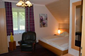 Un dormitorio con una cama y una silla negra. en Hotel Kärntnerhof Velden, en Velden am Wörthersee 20 fotos más