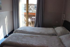 Dos camas en una habitación con ventana. en Hotel Kärntnerhof Velden, en Velden am Wörthersee