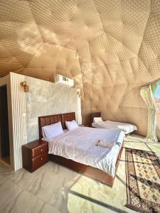a bedroom with a bed in a room with a ceiling at Wadi Rum March in Aqaba +20 photos
