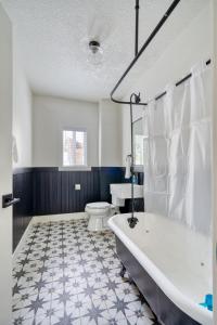 a white bathroom with a tub and a toilet at Stay Portland - Beautiful Brooklyn 1 Bed Apt in Portland