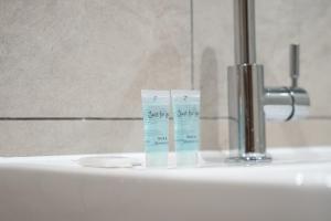 a bathroom sink with two tubes of toothpaste on it at Bath St Suite in Glasgow +19 photos