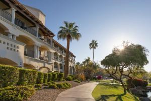 a walkway in front of a building with palm trees at Fairmont Scottsdale Princess in Scottsdale