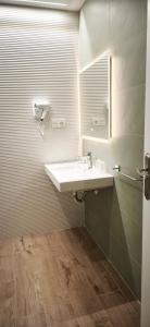 a bathroom with a sink and a mirror at Apartamento LORETO - Hotel Ruta del Segur in Pontones