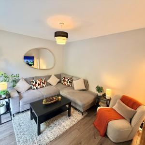 una sala de estar con un sofá y una mesa en Birmingham City Centre Lrg House - Sleeps 10 - Free Driveway Parking, en Birmingham
