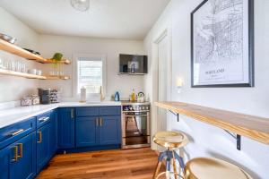 ポートランドにあるStay Portland - Brooklyn 1 Bedroom Stylish Suiteのキッチン(青いキャビネット、カウンター付)