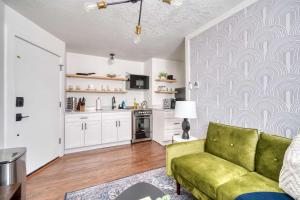 Una sala de estar con un sofá verde y una cocina. en Stay Portland - Beautiful Brooklyn 1 Bed Apt, en Portland