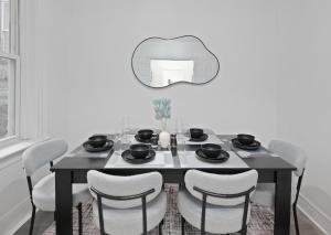 Una mesa de comedor con sillas y un espejo. en Deluxe 3 Bed Apt Min to NYC, en West New York 13 fotos más