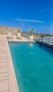a swimming pool with blue water on a beach at Tuk Tulum Estudio con Balcon 005 in Tulum