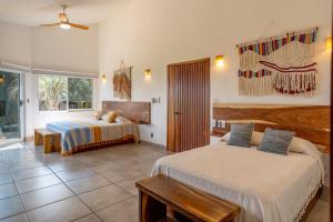 a hotel room with two beds and a window at Casa Cumbres - Ocean View in Puerto Escondido