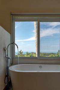 a bath tub in a bathroom with a window at Casa Cumbres - Ocean View in Puerto Escondido