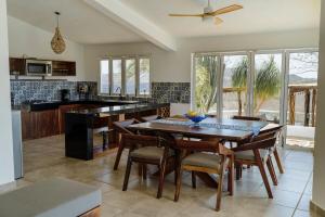 a kitchen with a table and chairs and a kitchen with a ceiling fan at Casa Cumbres - Ocean View in Puerto Escondido