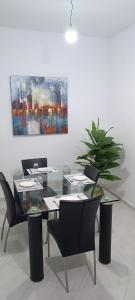 a dining room with a table and chairs and a painting at Maison de cèdre in Azrou +2 photos