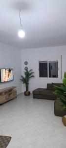 a living room with a couch and a tv at Maison de cèdre in Azrou