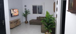 a living room with a couch and a plant at Maison de cèdre in Azrou