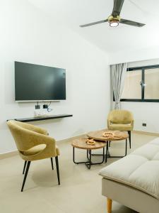 サン・フェリペ・デ・プエルト・プラタにあるOcean Winds Hotelのソファと椅子とテレビのあるリビングルーム
