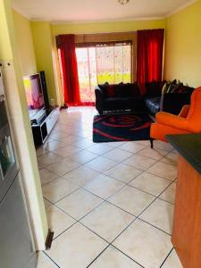 een woonkamer met een bank en een tv bij Central but hidden Gem in the Burbs in Northriding