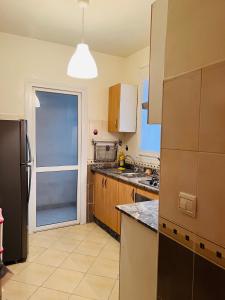a kitchen with a stainless steel refrigerator and a window at Appartement Fal oumlil in Agadir