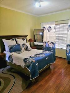 een slaapkamer met een groot bed met een blauw dekbed bij Central but hidden Gem in the Burbs in Northriding