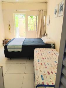 a small bedroom with a bed and a window at Residencial Praia Bertioga Pé na Areia in Bertioga