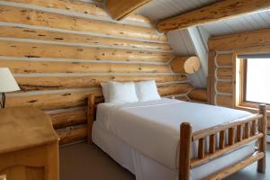 a bedroom with a bed in a log cabin at Silverthorne Cabin with Hot Tub and Forest Access in Silverthorne