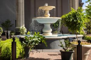 a fountain in front of a building with potted plants at The Riverfront Hotel New Orleans in New Orleans