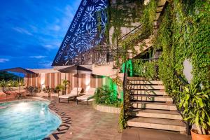 a building with a staircase next to a swimming pool at Hotel Osvé Boutique Cali in Cali