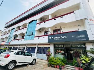 a white car parked in front of a building at Exclusive Premier Park Tvm in Trivandrum