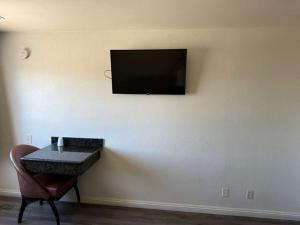 a room with a table and a television on a wall at Vista Motel in Los Angeles