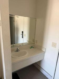 a bathroom with a sink and a large mirror at Vista Motel in Los Angeles