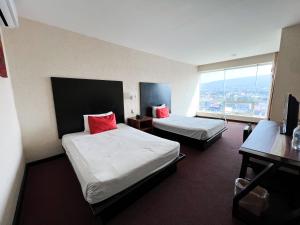a hotel room with two beds and a large window at Hotel Vista Inn Premium in Tuxtla Gutiérrez +31 photos