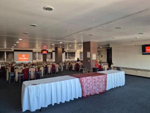 a banquet hall with white tables and people sitting at tables at Hotel Vista Inn Premium in Tuxtla Gutiérrez