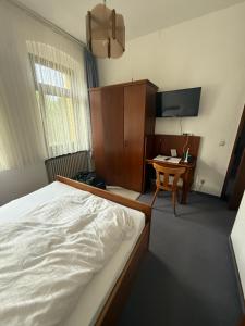 a bedroom with a bed and a desk and a television at Haus Danz in Brühl