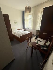 a bedroom with a bed and a desk and a table at Haus Danz in Brühl