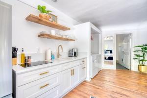 a kitchen with white cabinets and a hardwood floor at Serene Forest Studio - Walk to Multnomah Village in Portland