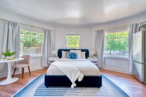 a bedroom with a bed and a desk and windows at Serene Forest Studio - Walk to Multnomah Village in Portland