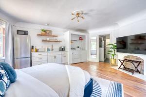 a kitchen with white cabinets and a bed in a room at Serene Forest Studio - Walk to Multnomah Village in Portland