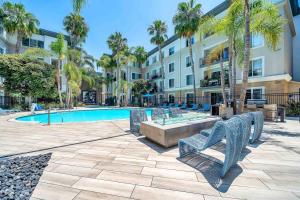 ロサンゼルスにあるPerfect Condo with Pool Spa & Gymの椅子と建物のあるプール