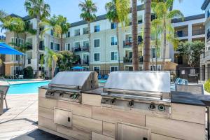 ロサンゼルスにあるPerfect Condo with Pool Spa & Gymの建物のあるプールの前のグリル