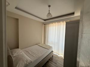 a small bedroom with a bed and a window at Maraş Blue Life Suit in Kahramanmaraş