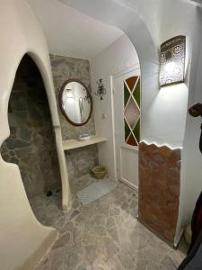 a bathroom with a stone floor and a mirror at Dar fenan Lina in Chefchaouen